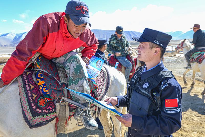 图为：汪会程正在给景区群众宣传普及常用法律法规.jpg
