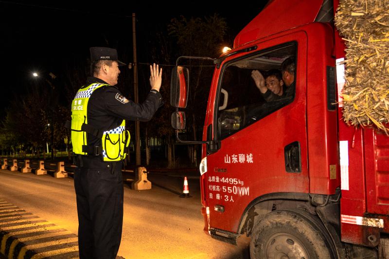 图为检查站民警帮助司机重新装载洒落的草垛。       .jpg