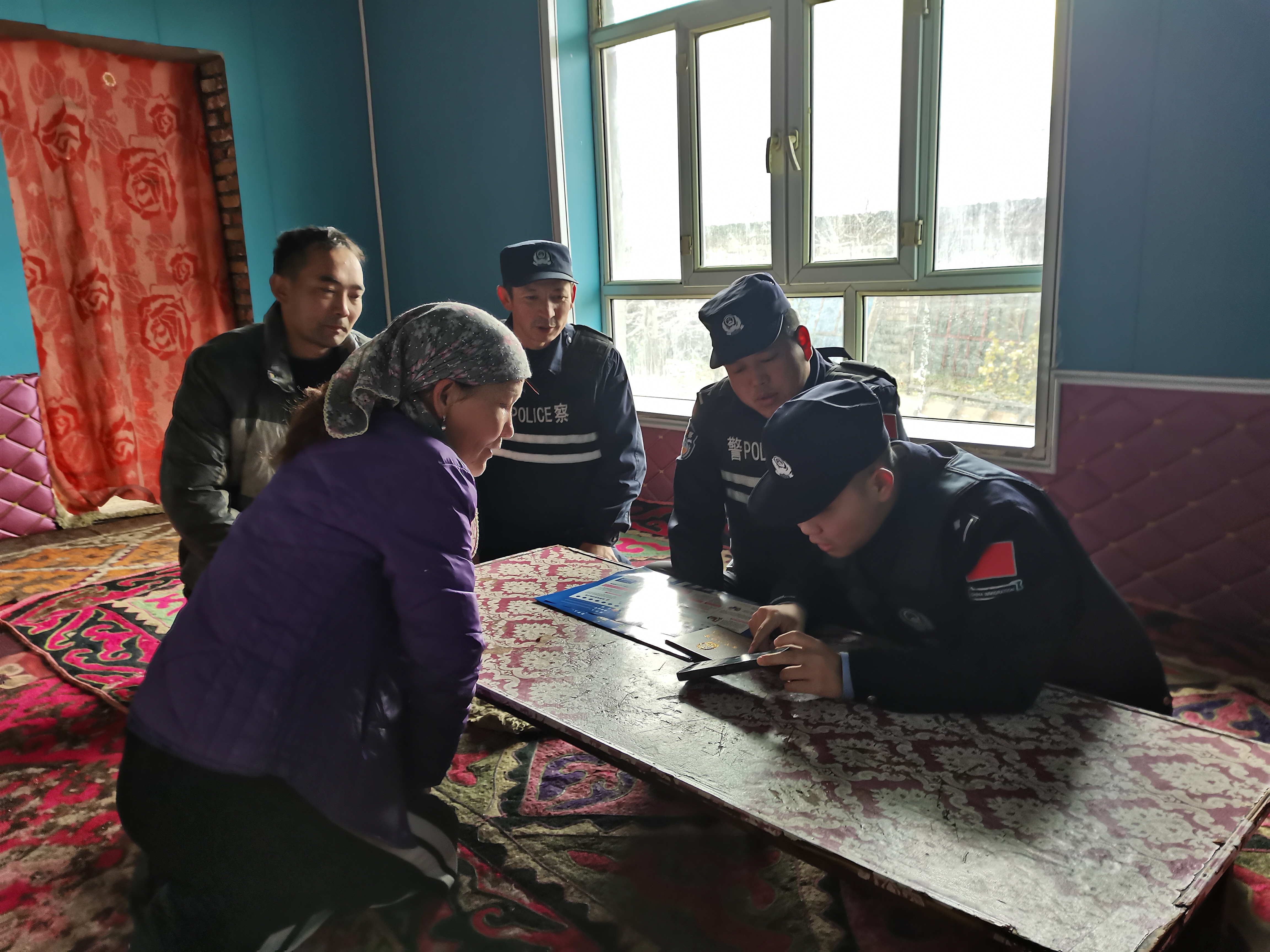 图为派出所民警正在开展送证上门活动，并手把手教群众使用“新疆政务服务”APP和“新疆公安微警务”小程序。.jpg