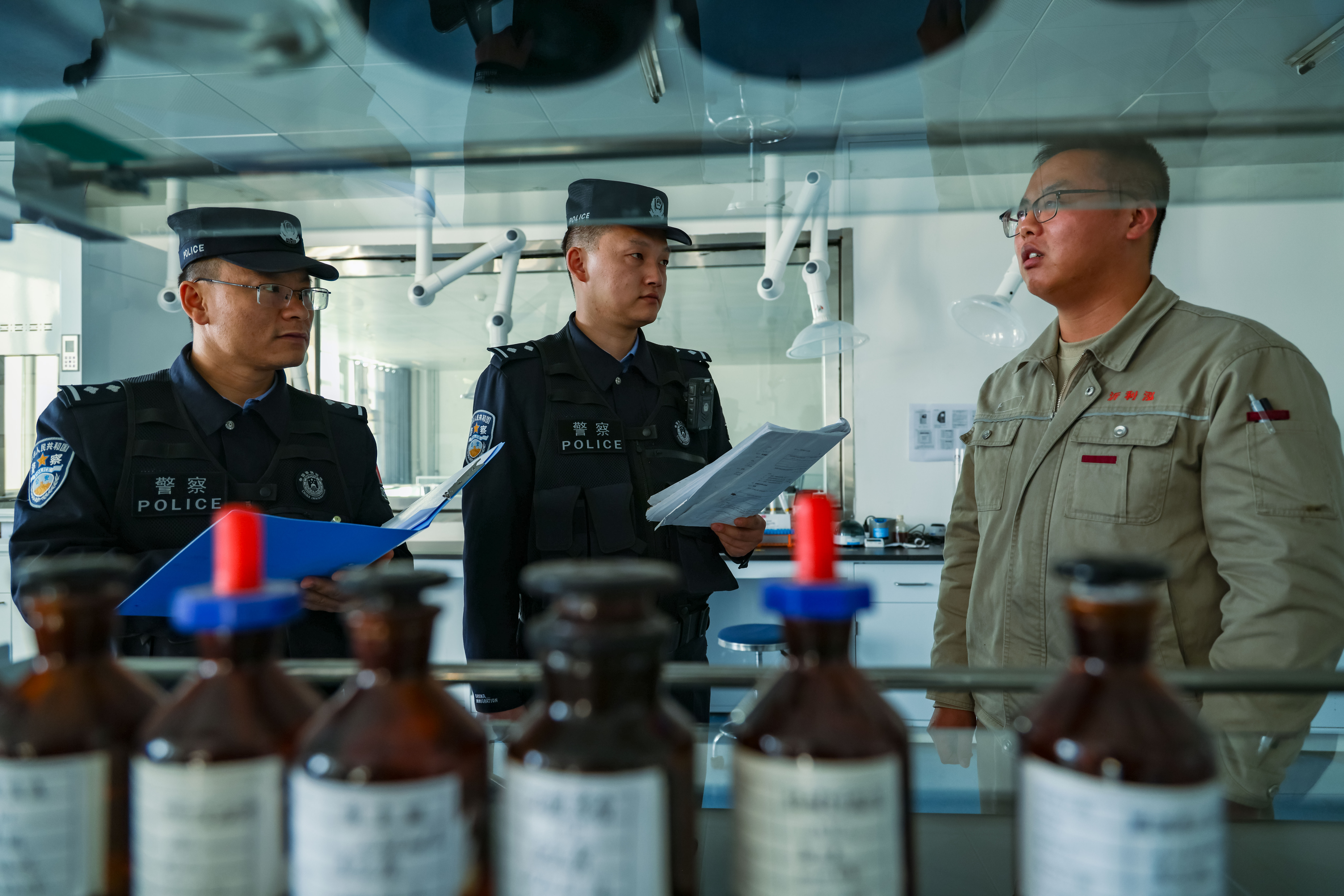 民警对实验室登记表进行检查.jpg
