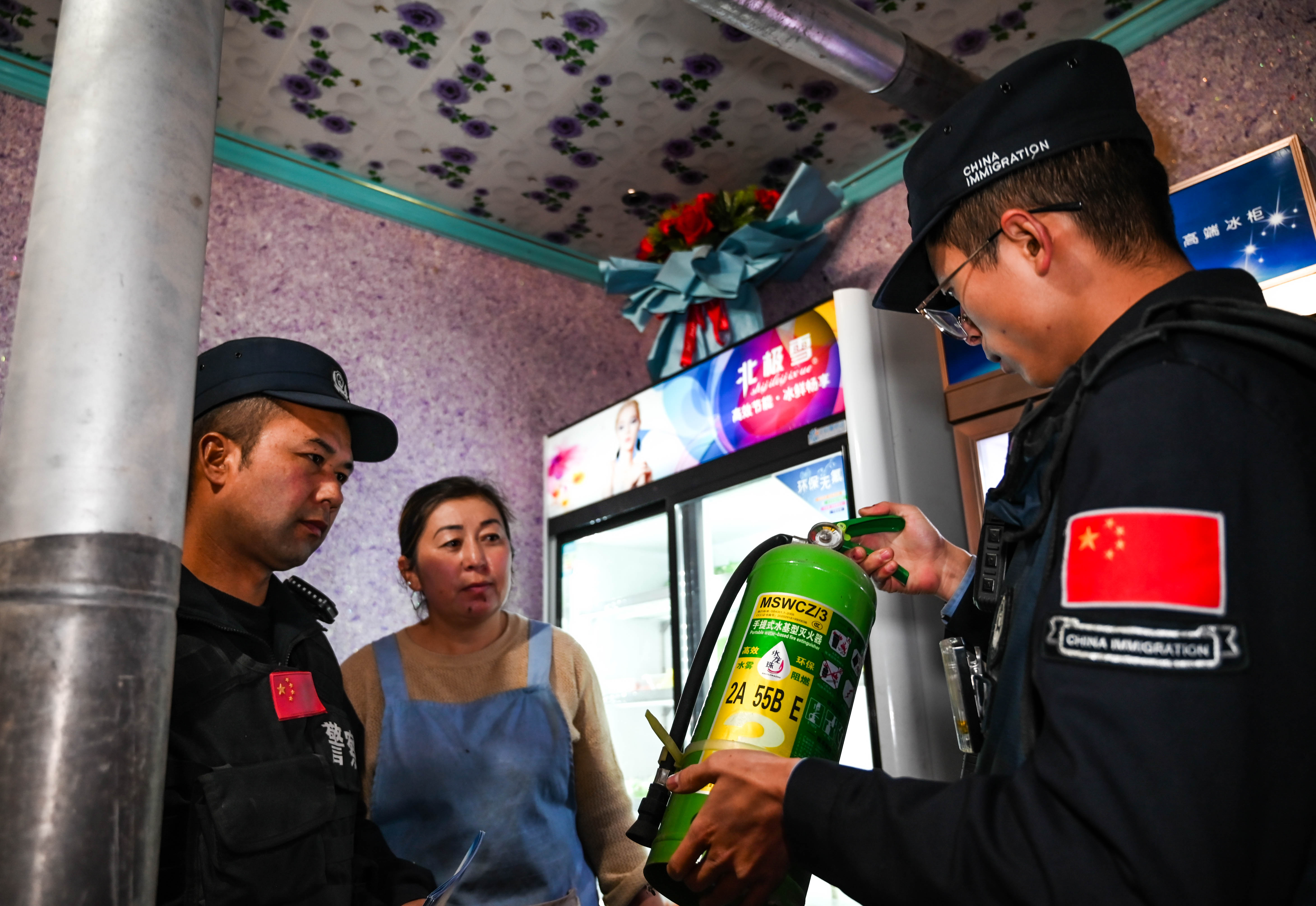 民警正在对餐厅的消防灭火器进行安全检查。 刘楠  摄.jpg