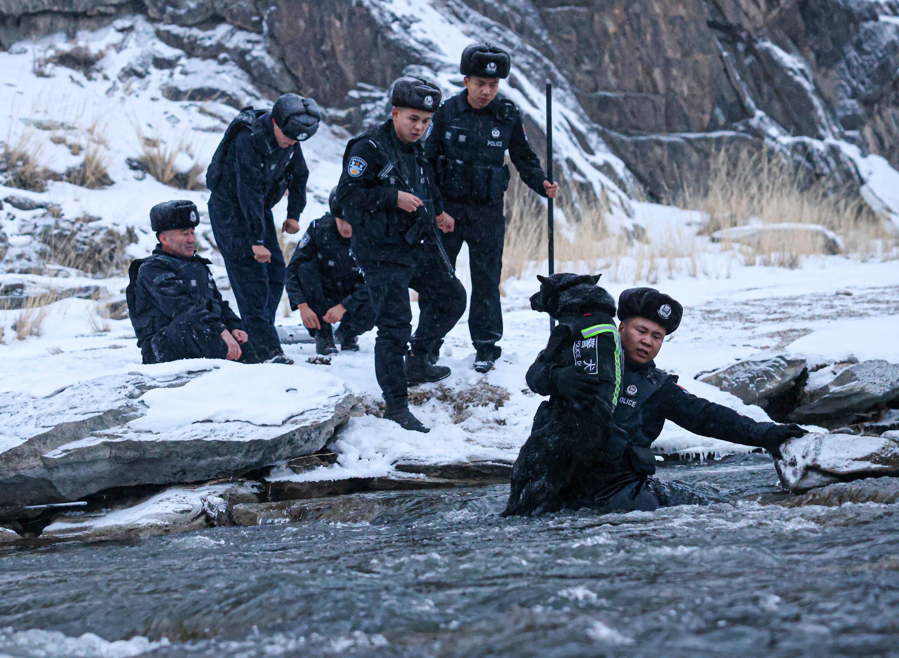 1图为2024年12月2日，民警正抱着警犬穿越冰河。.jpg