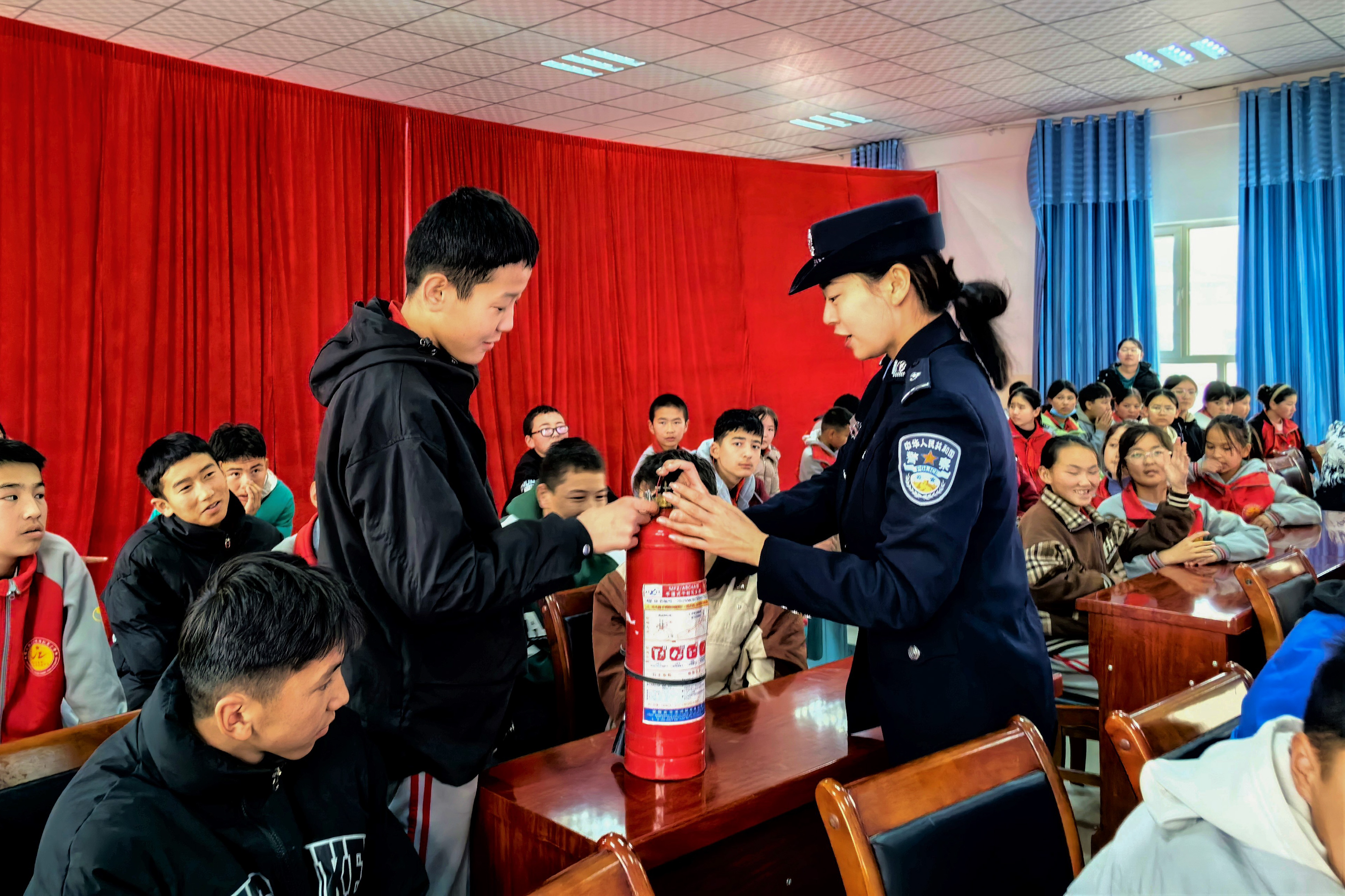 图为民警正在向学生讲解灭火器的相关知识3.jpg