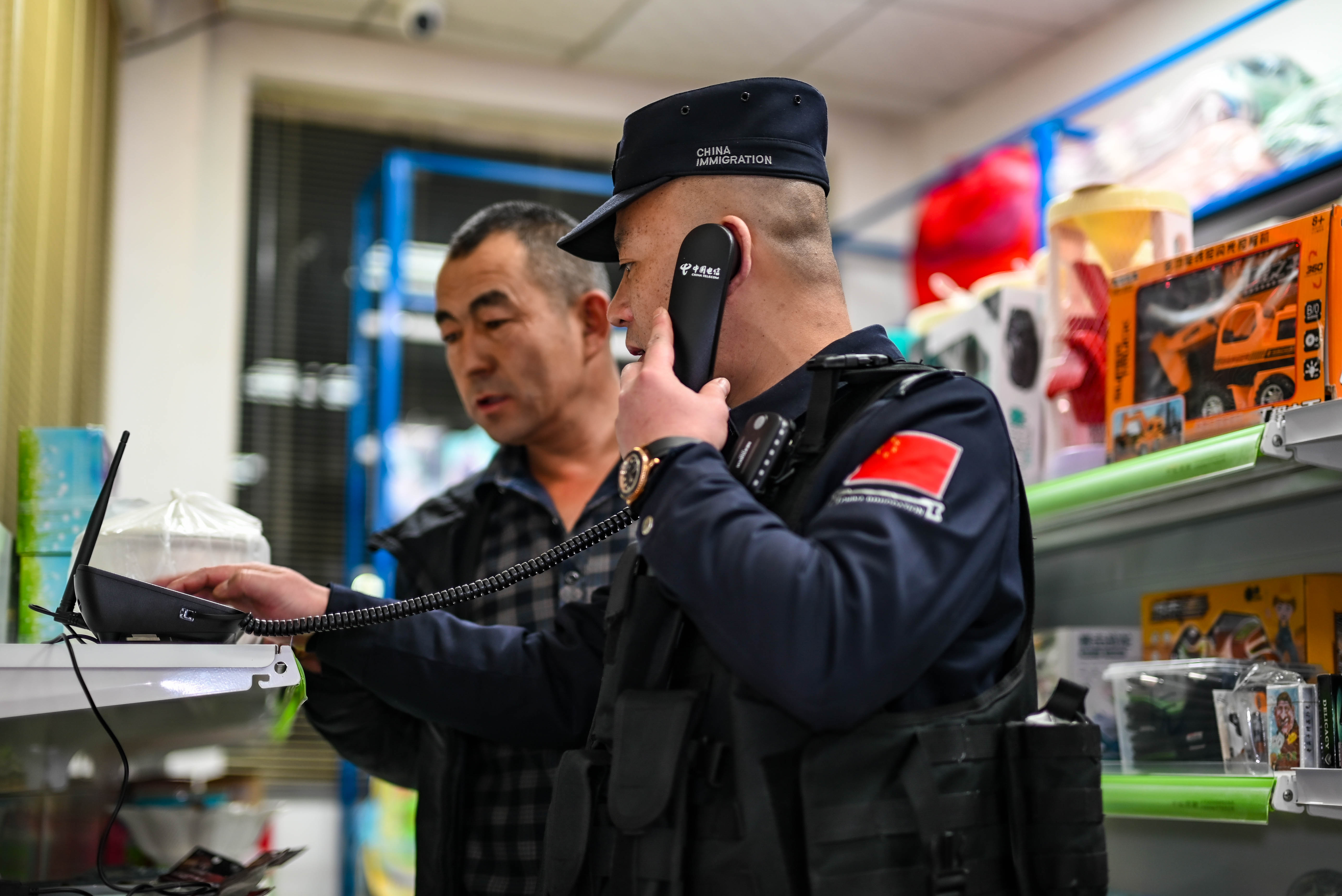图为民警正在对商铺一键式报警器进行安全检测。 刘楠  摄.jpg