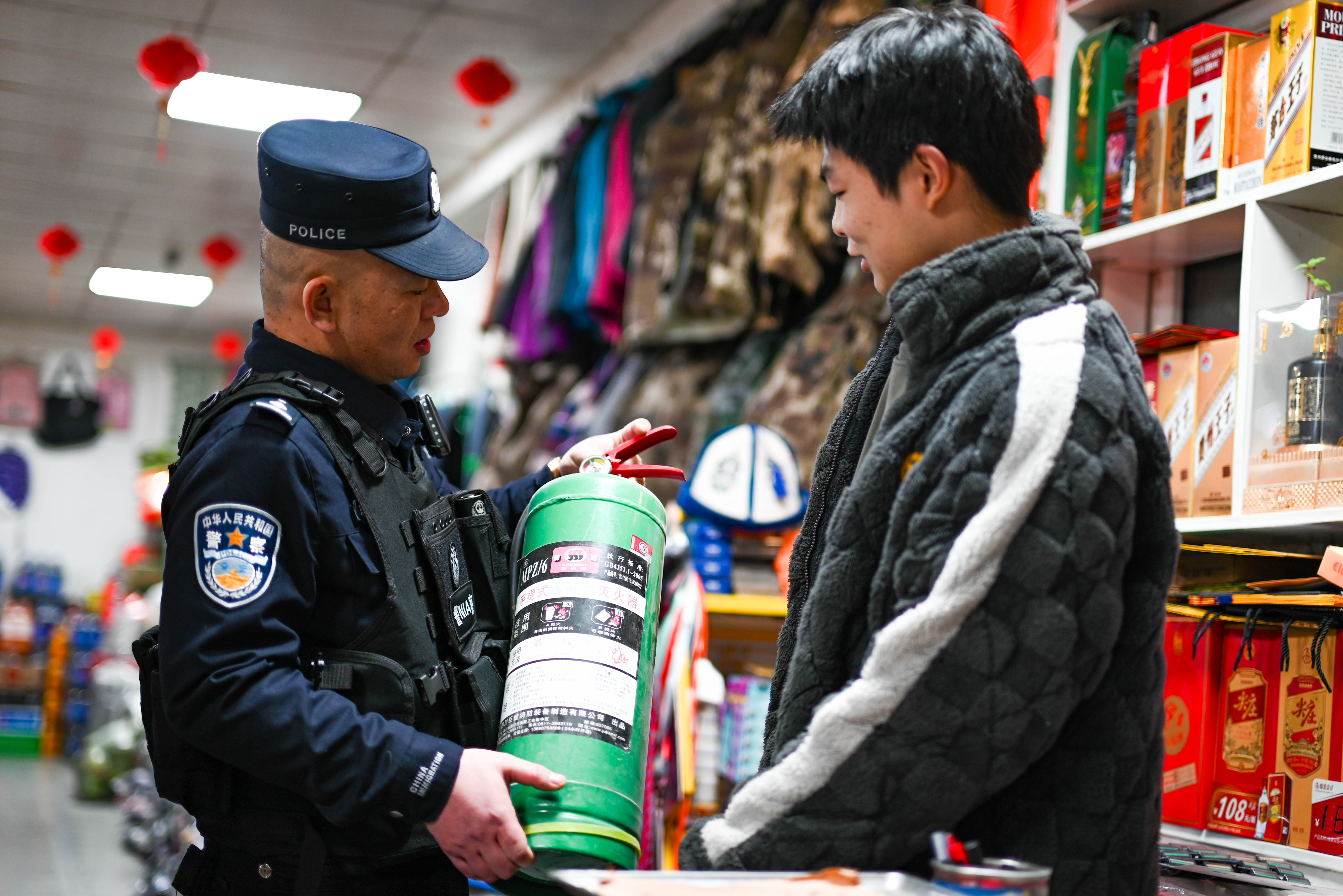 图为民警正在对超市的消防器材进行安全检查。 刘楠  摄.jpg