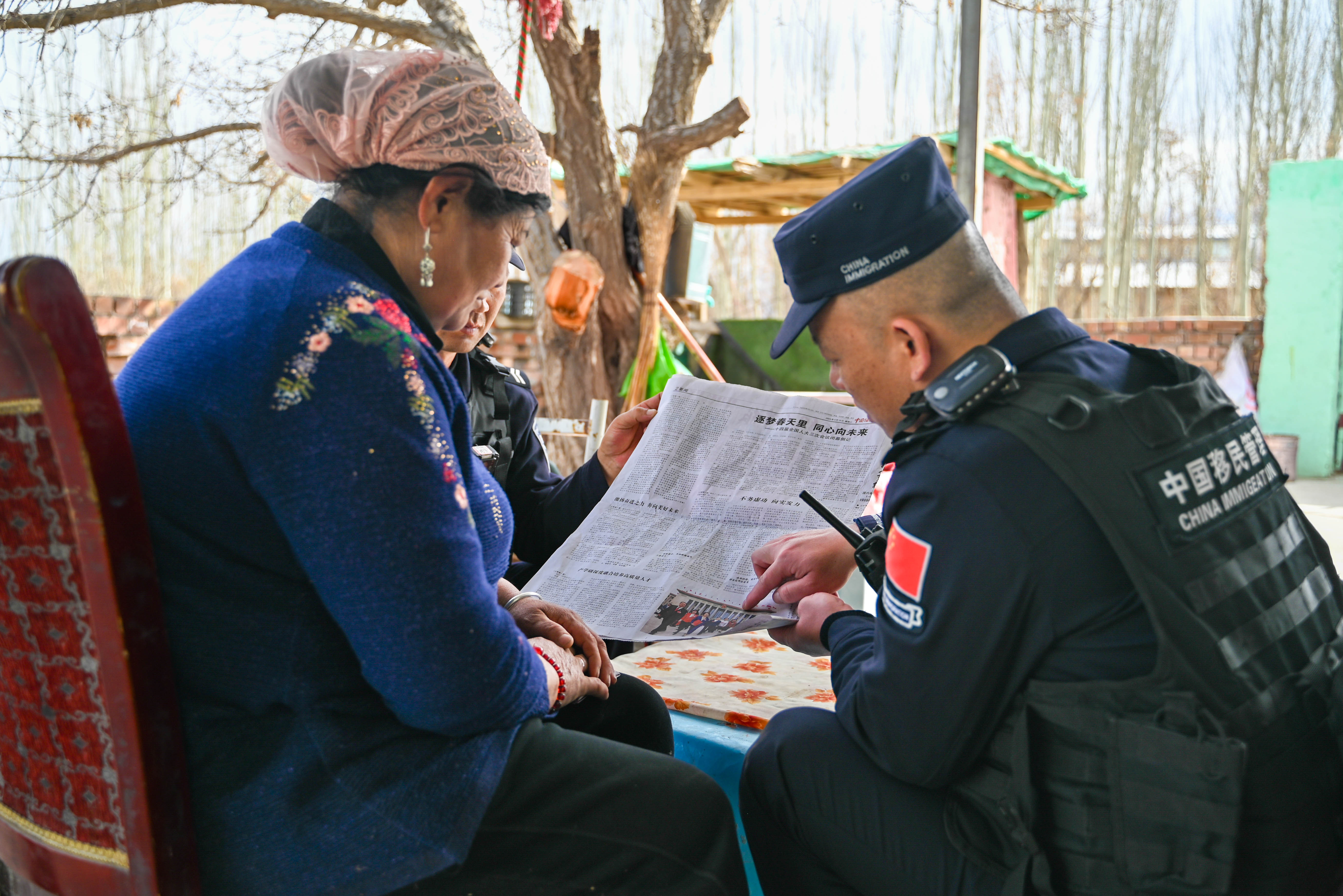 图为民警正在面对面向群众宣讲全国两会精神。 刘楠  摄 (2).jpg