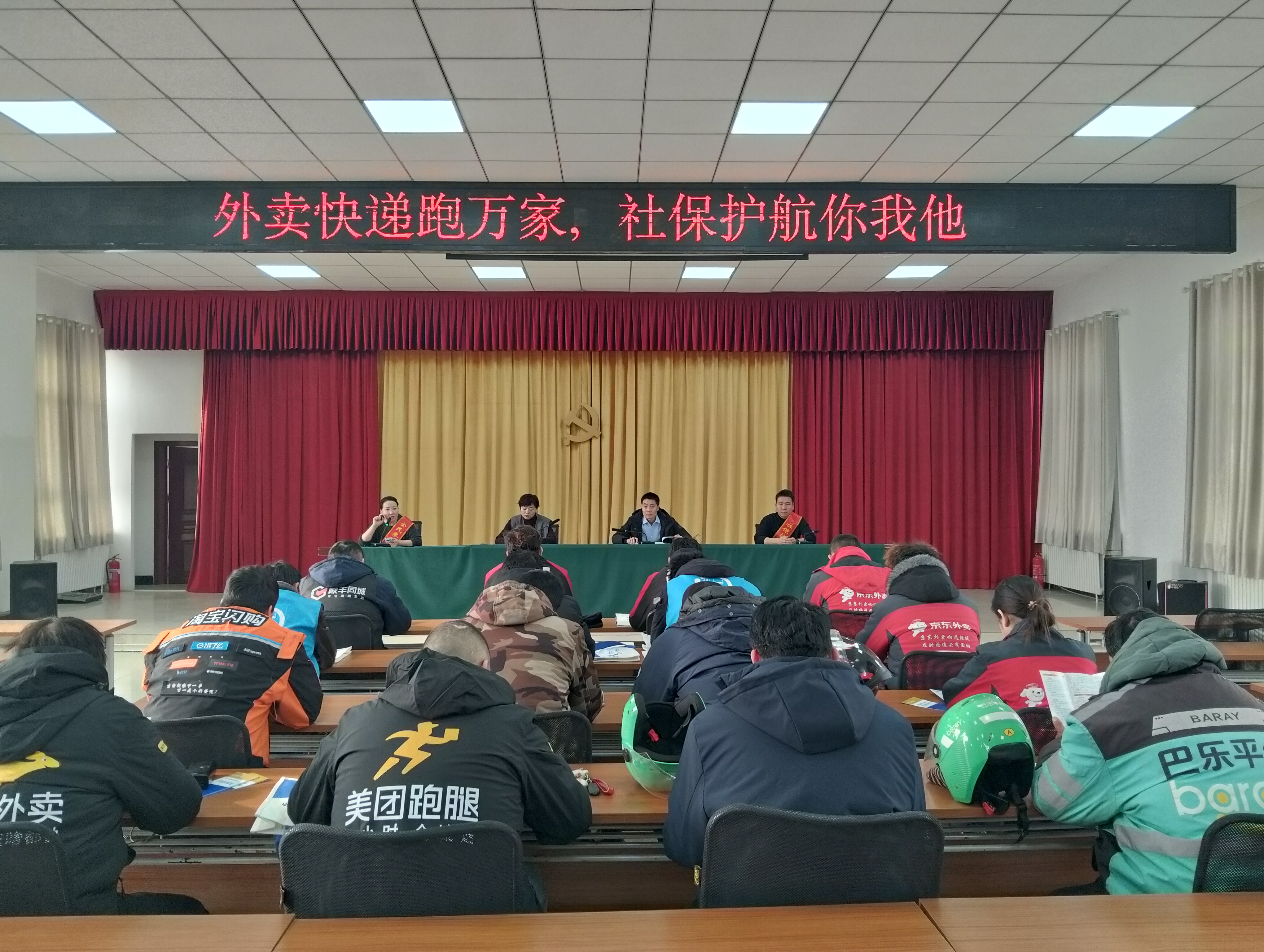 12月24日，沙雅县人社局社保中心联合县委社会工作部举办“外卖快递跑万家 社保护航你我他”政策宣讲会。图为骑手们齐聚一堂共享社保政策宣讲大礼包。.jpg