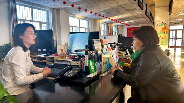 图为：12月25日，九师白杨市团结农场退休职工正在便民大厅咨询退休工资情况。苟汇敏摄.jpg