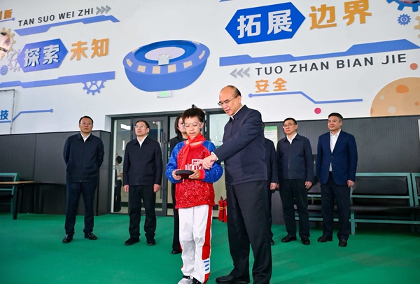 在哈尔滨市友协第二小学校，许勤来到航空兴趣小组观看学生日常训练。